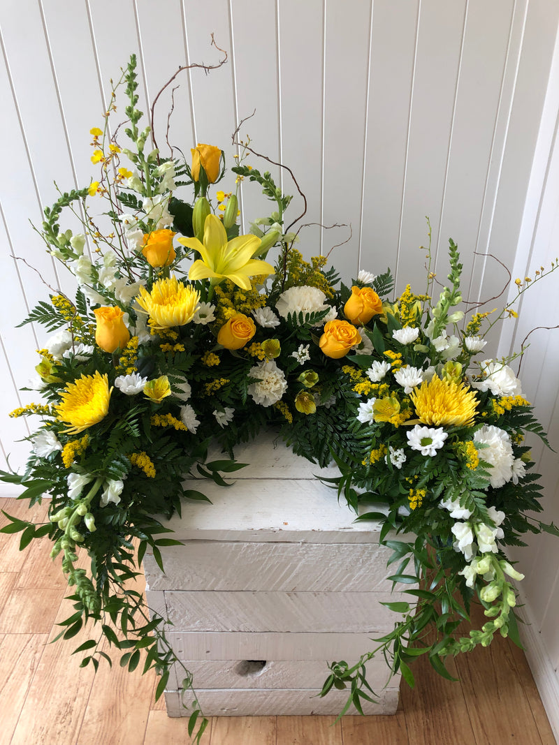 Asymmetrical yellow and white urn floral arrangement 